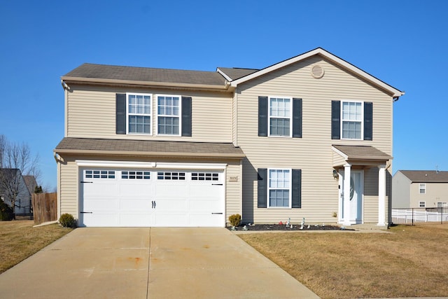 traditional home with an attached garage, concrete driveway, a front yard, and fence