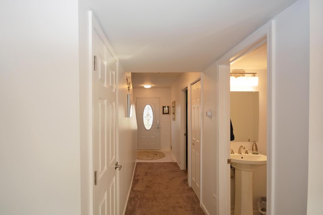 corridor featuring carpet floors and a sink