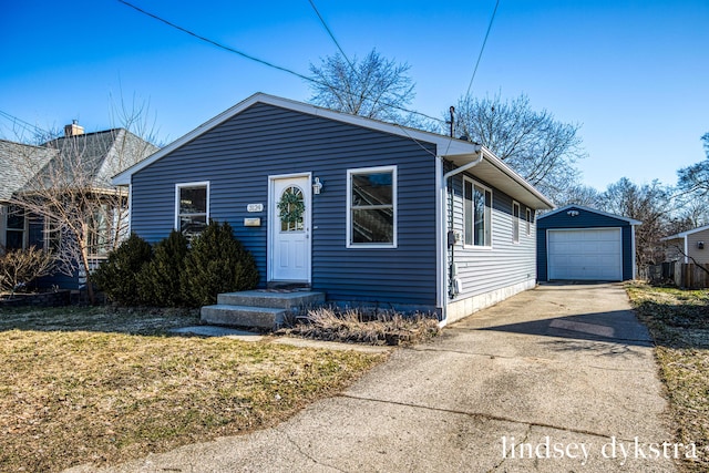 view of front of house featuring concrete driveway, an outbuilding, and a garage