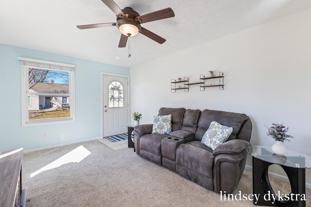 carpeted living area with ceiling fan, a textured ceiling, and baseboards