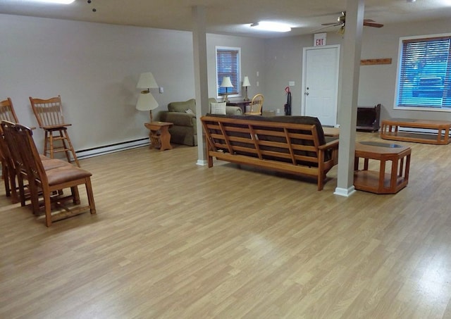 living area featuring a ceiling fan, wood finished floors, and baseboard heating