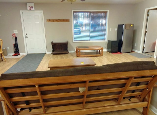 dining space with wood finished floors, a ceiling fan, and baseboards