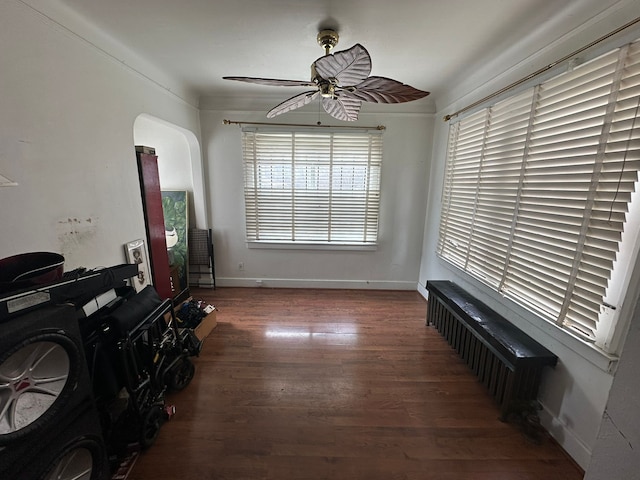 living room featuring ceiling fan, baseboards, and wood finished floors