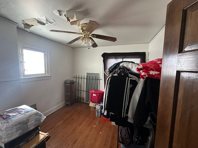 bedroom with a ceiling fan, baseboards, and wood finished floors