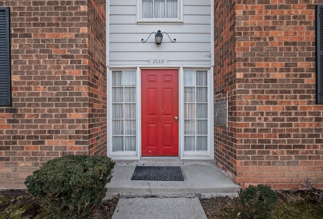 entrance to property featuring brick siding