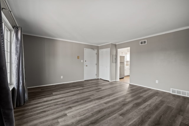 interior space with visible vents, baseboards, dark wood finished floors, and ornamental molding