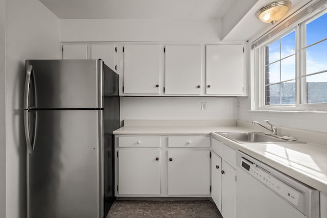 kitchen featuring a sink, freestanding refrigerator, white cabinets, light countertops, and dishwasher