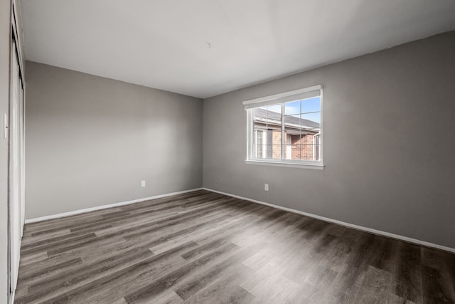 unfurnished room with baseboards and wood finished floors