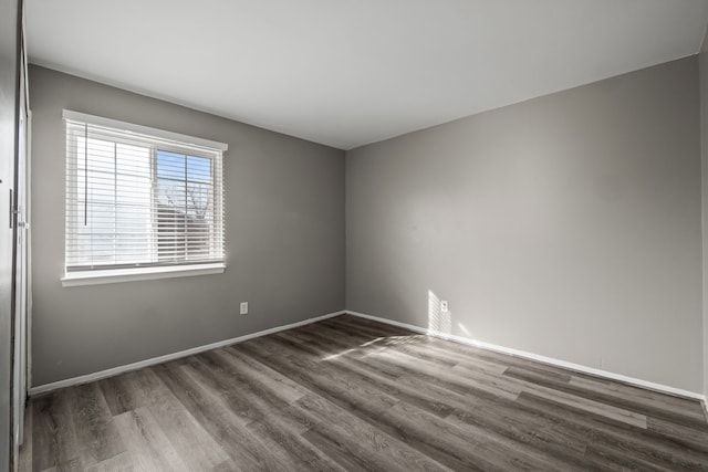 empty room with baseboards and wood finished floors