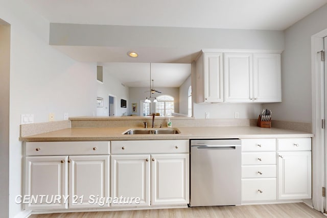 kitchen with a sink, white cabinetry, light countertops, and stainless steel dishwasher