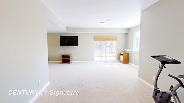 workout room featuring carpet and baseboards