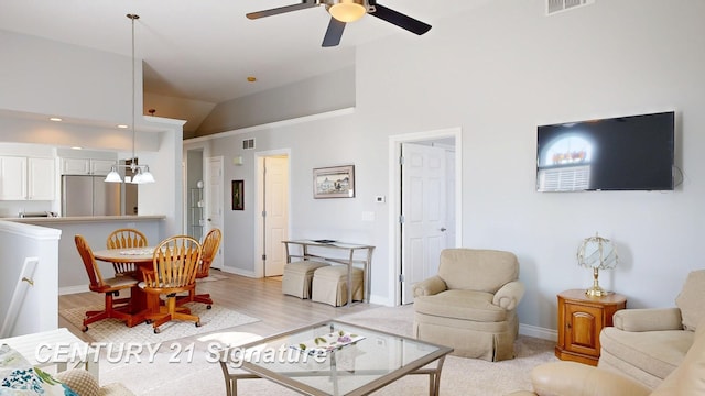 living room featuring light wood-type flooring, visible vents, a ceiling fan, baseboards, and lofted ceiling