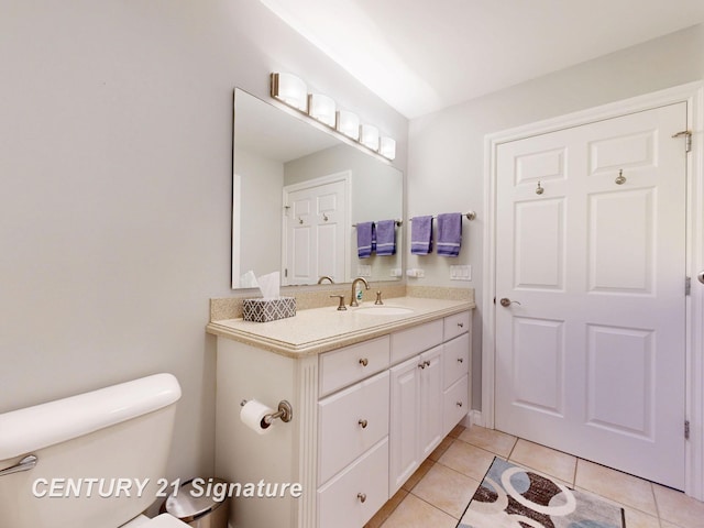 half bath with vanity, tile patterned floors, and toilet