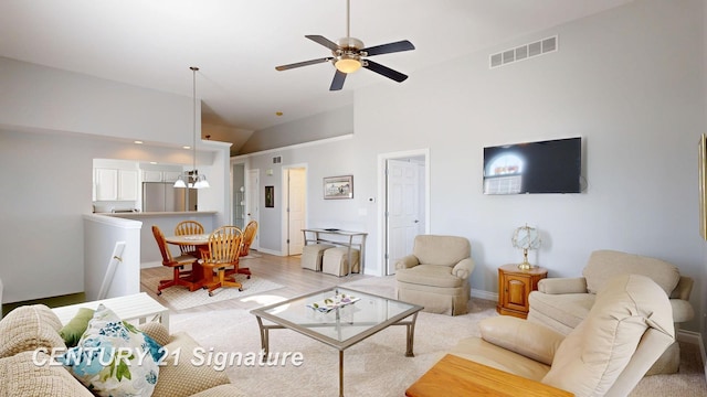 living area with high vaulted ceiling, baseboards, visible vents, and ceiling fan