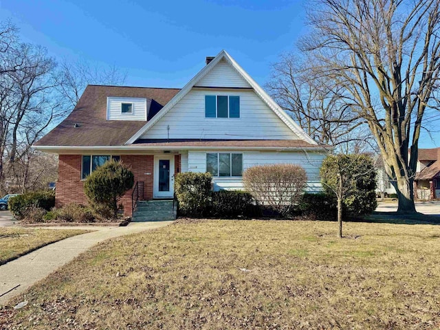 view of front facade with brick siding and a front lawn