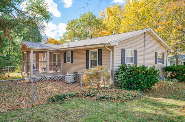 view of side of home featuring cooling unit, a yard, fence private yard, and a sunroom