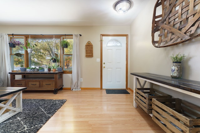 foyer with light wood-style flooring and baseboards