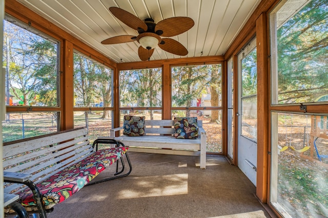 unfurnished sunroom with wood ceiling and ceiling fan