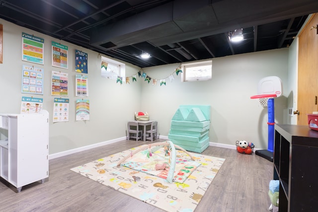 game room with baseboards and wood finished floors