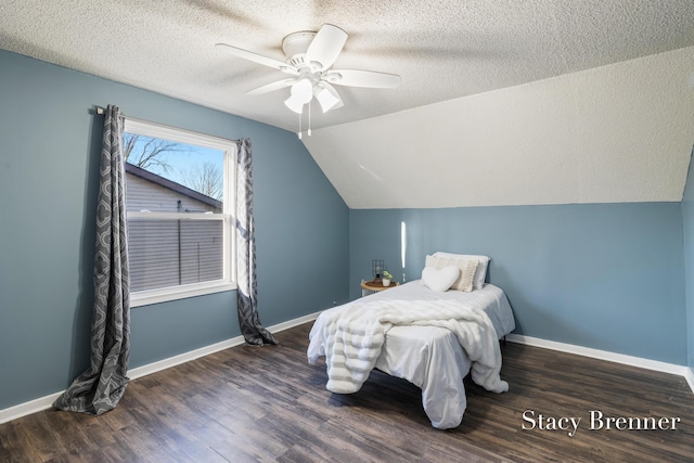 bedroom featuring vaulted ceiling, a textured ceiling, and wood finished floors