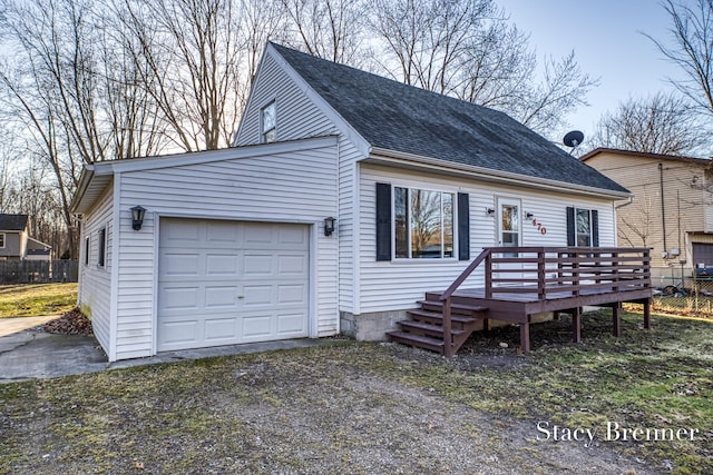 view of front of property featuring fence, a garage, driveway, and a shingled roof