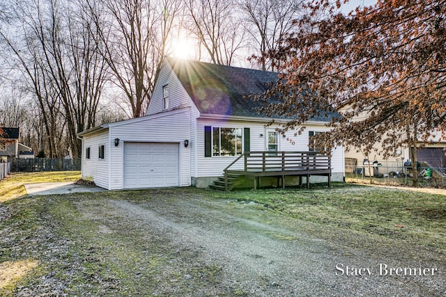 view of front of property featuring driveway, fence, a garage, and roof with shingles