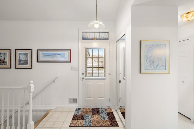 foyer with light tile patterned flooring, baseboards, and visible vents