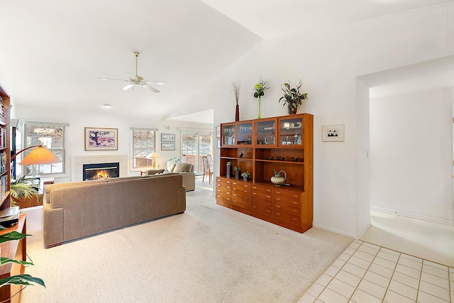 tiled living room with ceiling fan, a fireplace, lofted ceiling, and carpet floors