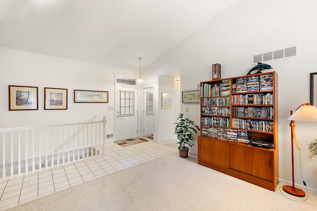 interior space featuring tile patterned flooring, vaulted ceiling, visible vents, and carpet floors