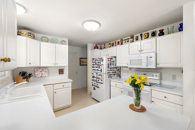 kitchen with white cabinets, white appliances, light countertops, and a sink