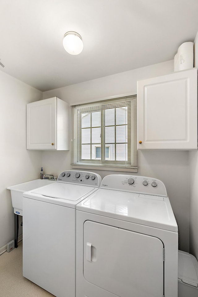 laundry room with visible vents, washer and dryer, cabinet space, baseboards, and light colored carpet