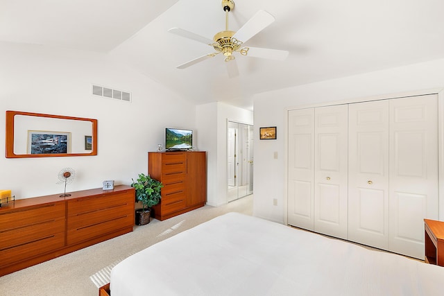 bedroom with visible vents, a closet, carpet floors, lofted ceiling, and ceiling fan