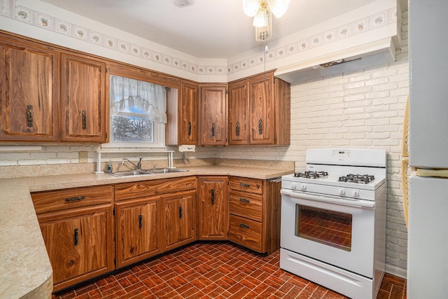 kitchen with a sink, white range with gas stovetop, light countertops, and custom range hood