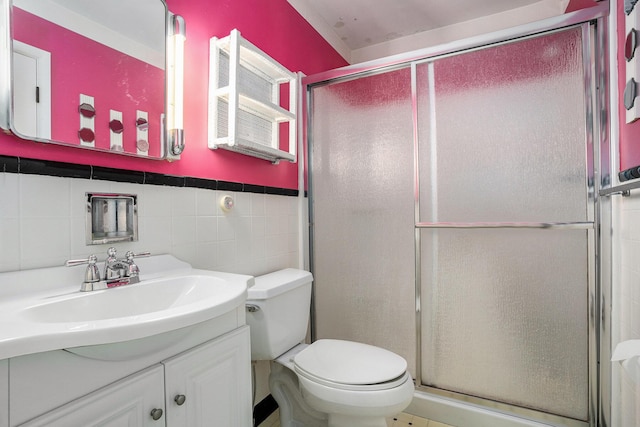 full bathroom featuring toilet, tile walls, a stall shower, and vanity