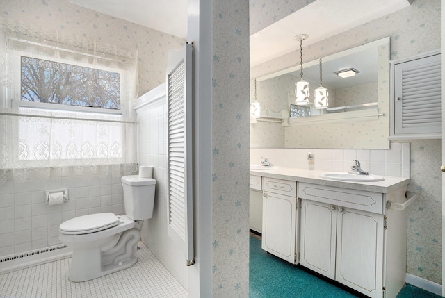 bathroom with a sink, a baseboard heating unit, toilet, and wallpapered walls