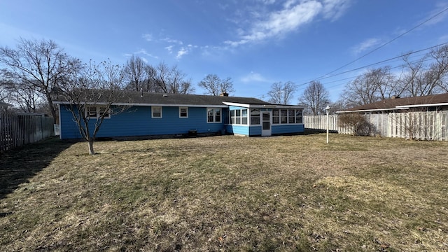 back of house with a lawn, a fenced backyard, and a sunroom