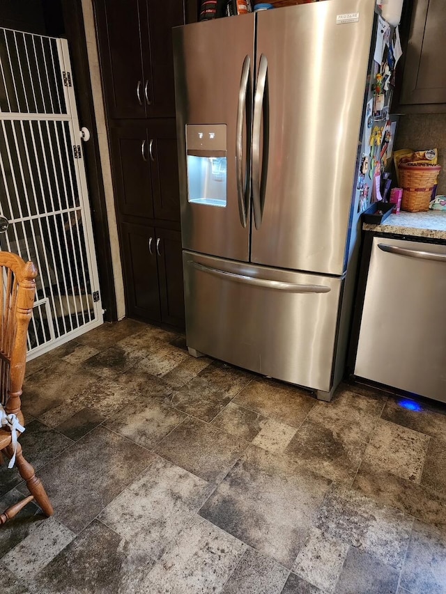 kitchen with appliances with stainless steel finishes and stone finish flooring