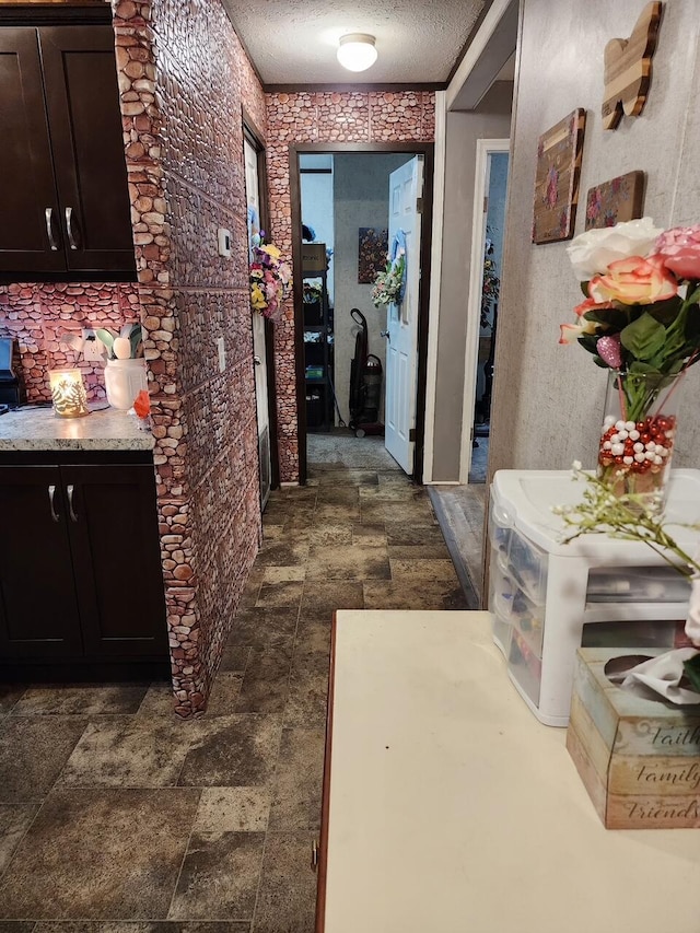 hall with stone finish flooring and a textured ceiling