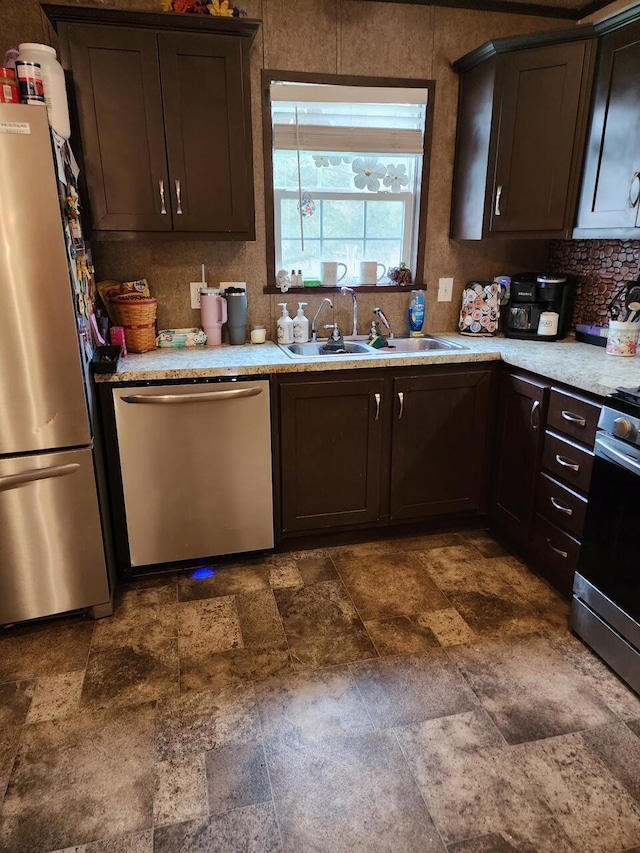 kitchen with a sink, dark brown cabinetry, light countertops, and stainless steel appliances