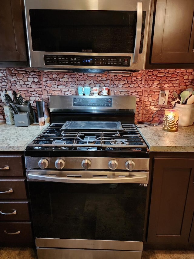 kitchen with dark brown cabinetry, backsplash, and appliances with stainless steel finishes