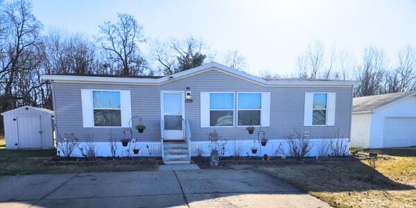 manufactured / mobile home with a storage unit, an outdoor structure, and entry steps