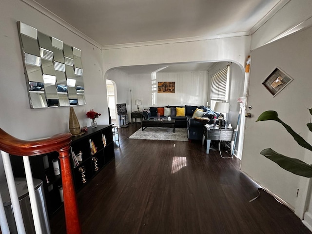 hallway featuring wood finished floors, arched walkways, and ornamental molding