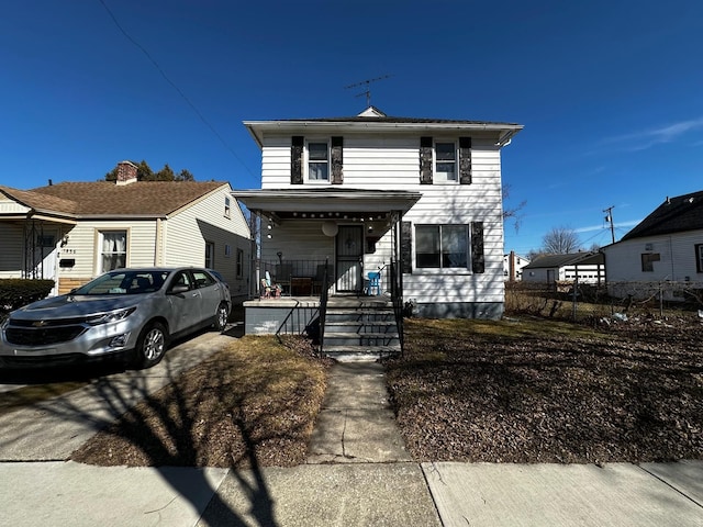 view of front of home featuring covered porch and fence