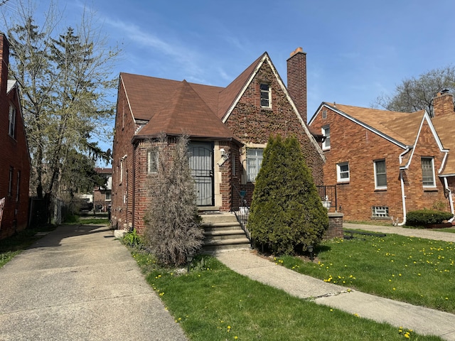 view of front of property featuring brick siding and a front lawn