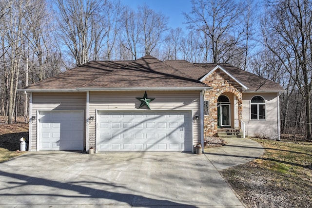 single story home with concrete driveway, a garage, and roof with shingles