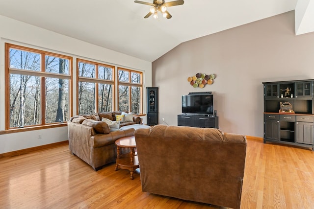 living area featuring baseboards, light wood-style flooring, a ceiling fan, and lofted ceiling