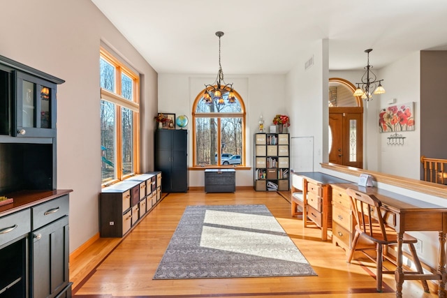 interior space featuring an inviting chandelier, visible vents, light wood-type flooring, and baseboards