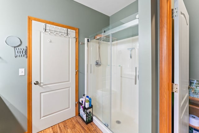 bathroom with a stall shower and wood finished floors