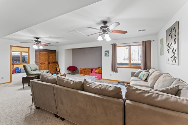 living area featuring light carpet, visible vents, baseboards, and a ceiling fan