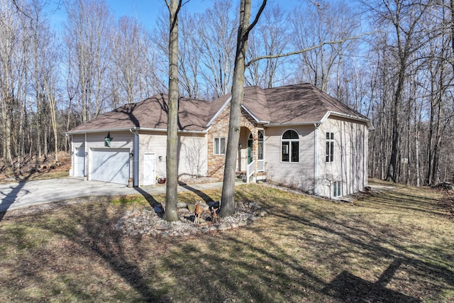 single story home featuring a garage, concrete driveway, and a front yard